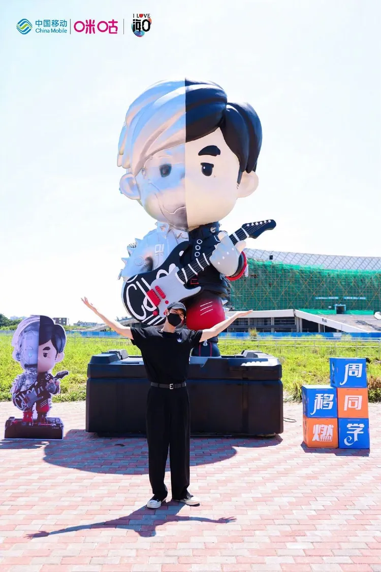 李現與大型周杰倫造型公仔合照打卡，追星粉的快樂大家都懂。翻攝咪咕視頻微博