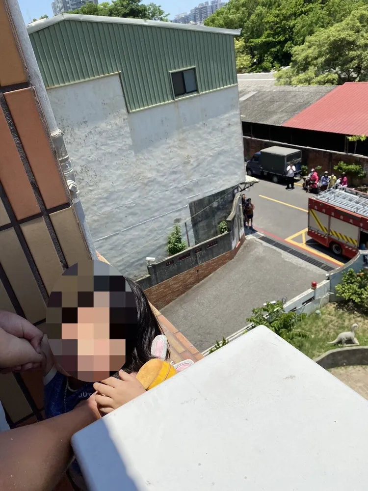警消破門進屋，趕緊將小女孩抱回屋內。讀者提供