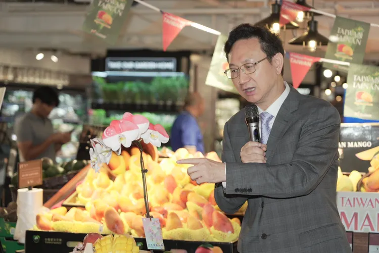 童振源介紹噴印新加坡國旗的台南蝴蝶蘭。市府提供