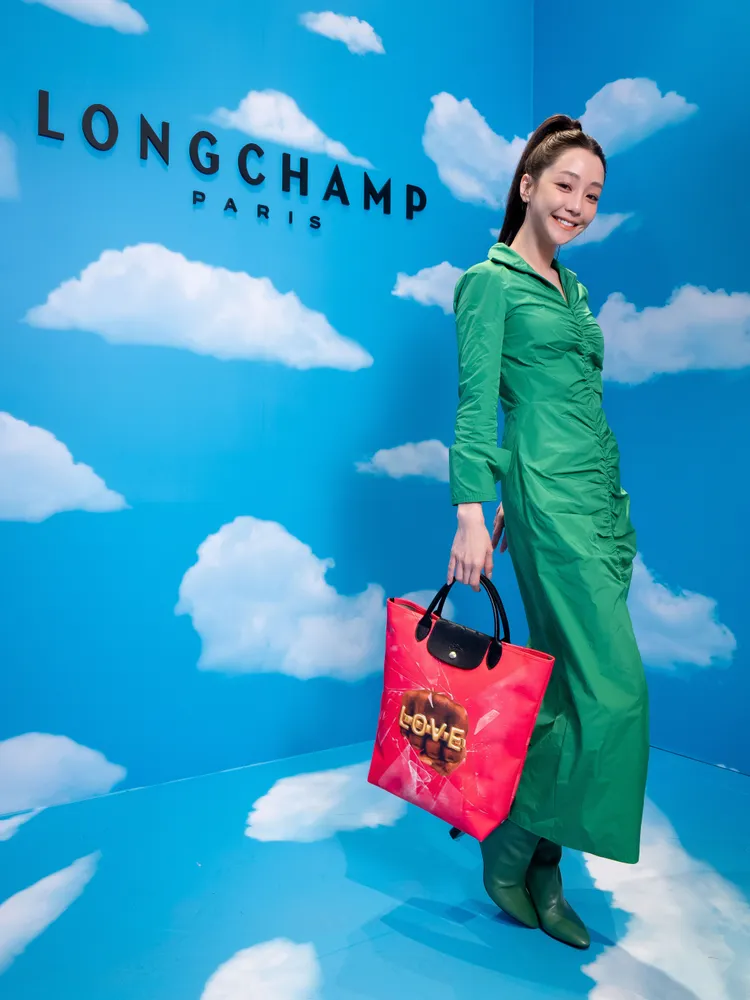 首度挑戰鮮綠色洋裝的謝欣穎，手拿印著拳頭圖案的粉色提袋出場，格外符合她喜歡不斷突破自我形象的個性。品牌提供