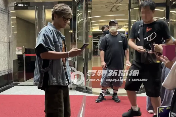 身為「時間管理大師」的小豬（左）在粉絲排隊時，滑手機看訊息。特勤中心攝