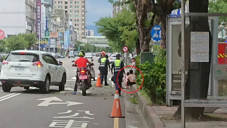 陳女及侄子坐在路邊等候救護車。民眾提供