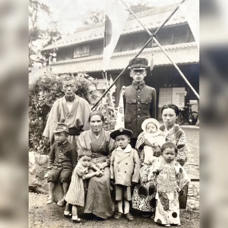 睦田繁義出征前的家族合照中，他就舉著武運長久旗。翻攝列星頓號博物館臉書@USS Lexington Museum