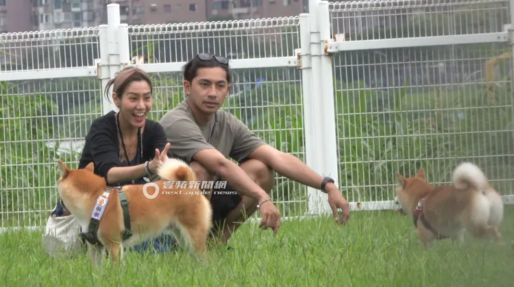 鄭楠鐘（右）與神似小温貞菱女友一同蹲下來，看見狗狗在奔跑，臉上表情相當開心。特勤中心攝