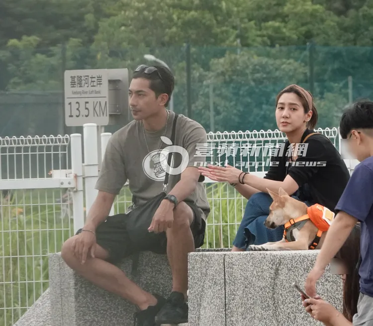 鄭楠鐘（左）與女友一同坐在設施上，看著狗狗盡情奔跑玩耍。特勤中心攝