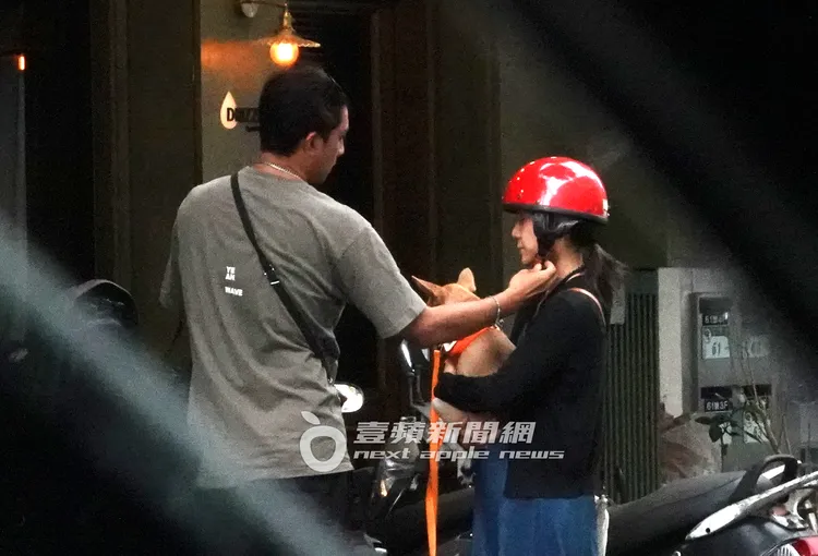 鄭楠鐘（左）貼心的幫女友卸下安全帽扣子，畫面充滿粉紅泡泡。特勤中心攝