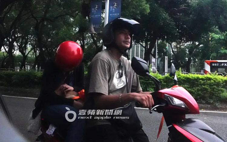 鄭楠鐘（右）騎著機車，坐在後座的女友不時的安撫著愛撒嬌的愛犬。特勤中心攝