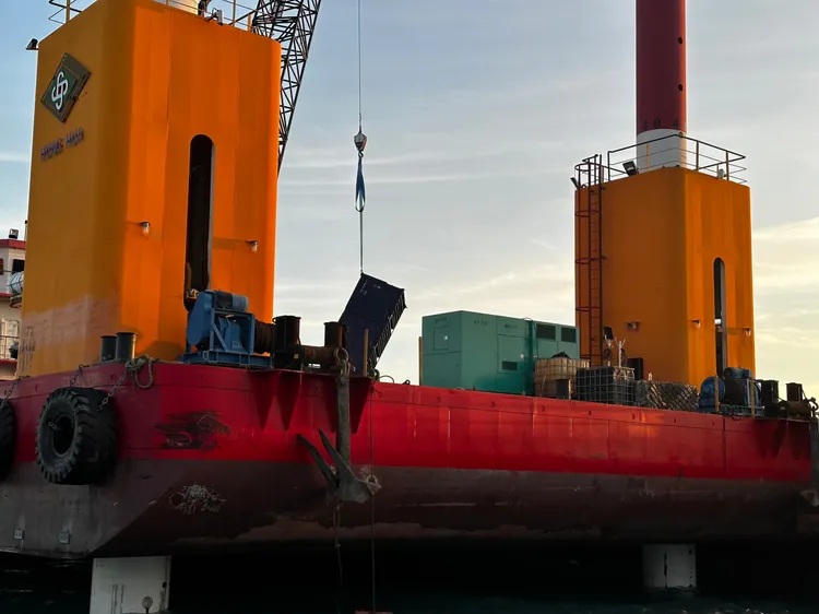 高雄港務公司動員船隻打撈落海貨櫃，勾吊上平台船。高港公司提供