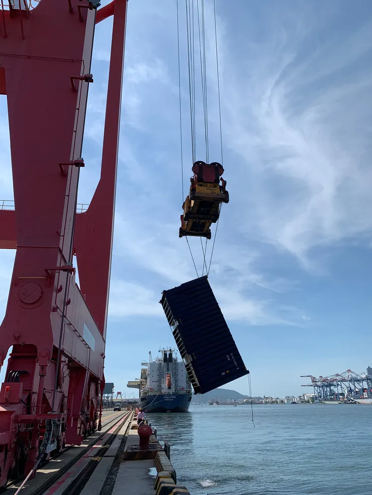 高雄港務公司動員船隻打撈落海貨櫃，以機具起水上岸。高港公司提供