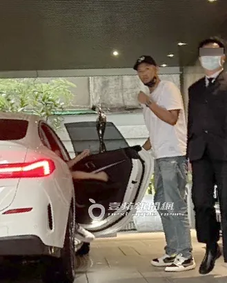 陳建州口罩戴一半，一身輕裝從白色BMW轎車副駕下車，後座疑似是范范。特勤中心攝