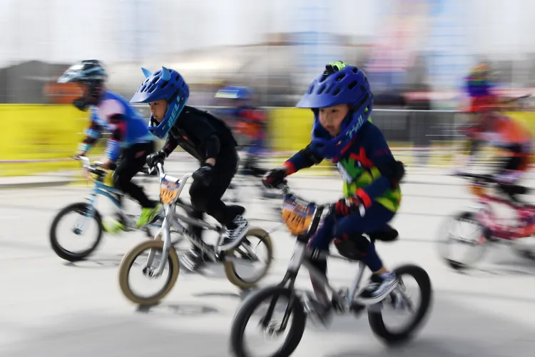 中國甘肅蘭州，在體育館中騎車競速的兒童。