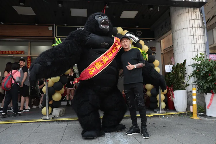 鳳梨(右)開新店，抖音爆紅的大猩猩前來表演祝賀。彭欣偉攝