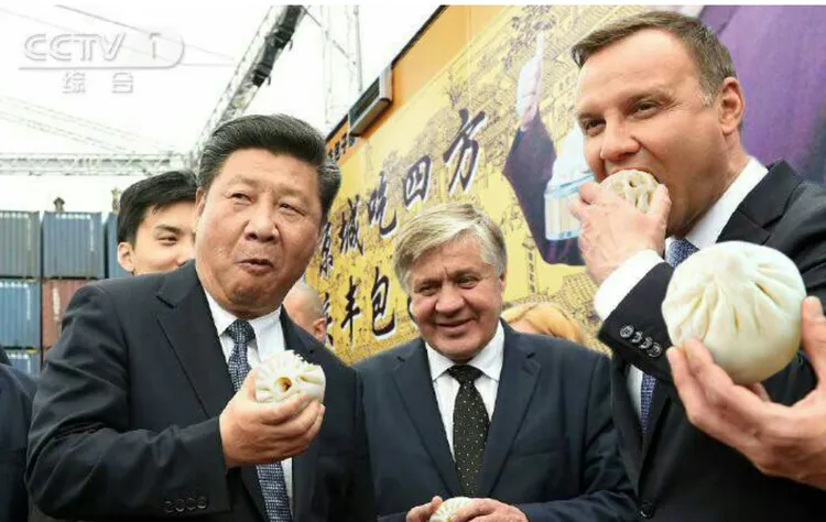中國國家主席習近平（左一）向波蘭促銷包子，當場大口吃包子。翻攝中國中央電視台