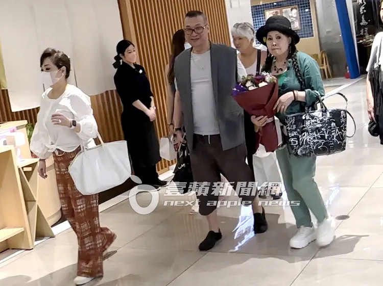 歐陽菲菲（右起）手裡捧著一束花，在洪偉明和Judy孫陪同下離開餐廳。特勤中心攝