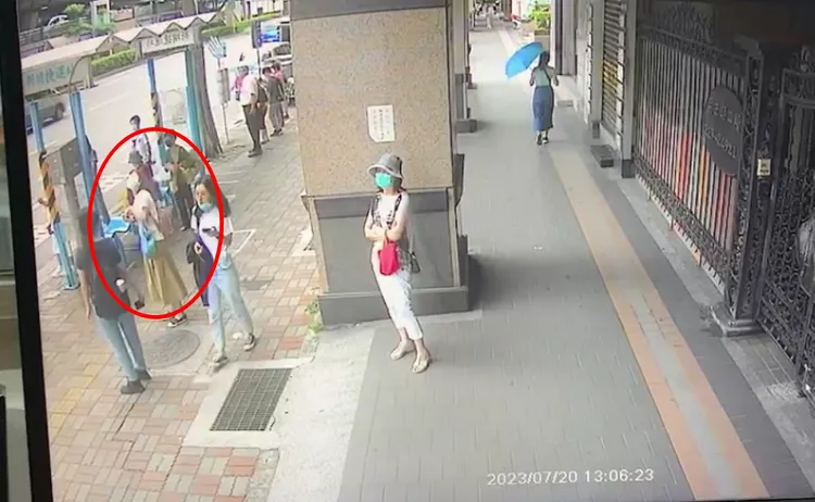 冷氣掉落前，一旁女民眾曾抬頭一看並趕緊躲過。翻攝畫面