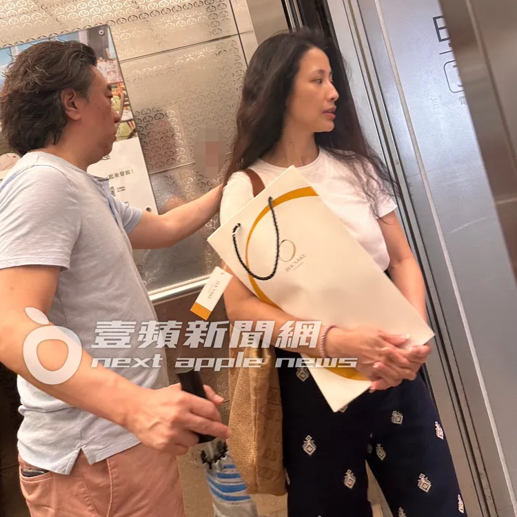 李蒨蓉（右）準備走出電梯，老公李德立貼心幫忙按開門鈕，從小細節就看得出平時對她照顧有加。讀者提供