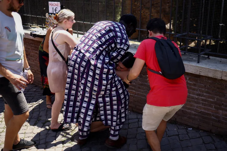 遊客7月11日在羅馬競技場附近熱暈，在場人士提供援助。路透社