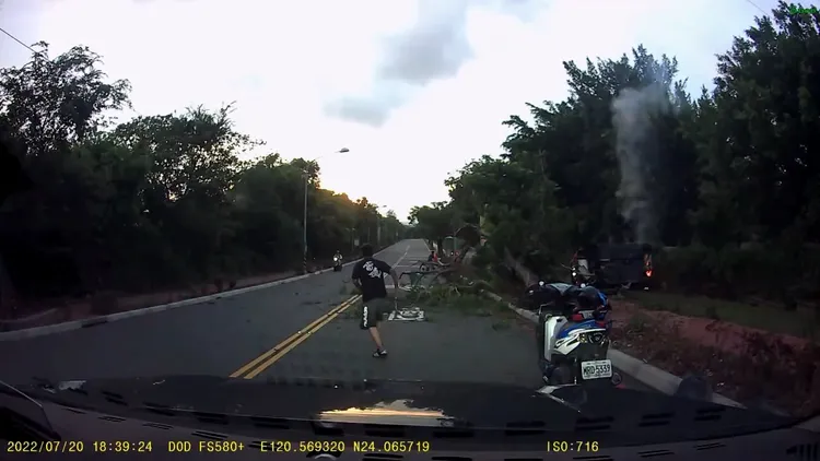 跑車翻覆後起火，機車騎士停在路邊前往搶救駕駛。民眾提供