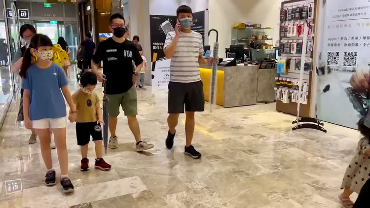 大小朋友帶著雨具出門去逛街。王志弘攝