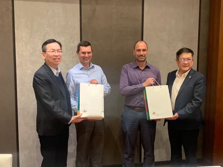 民航局長林國顯（左一）與機場公司董事長楊偉甫（右一）與美國運輸安全管理局官員互贈紀念品。桃機提供