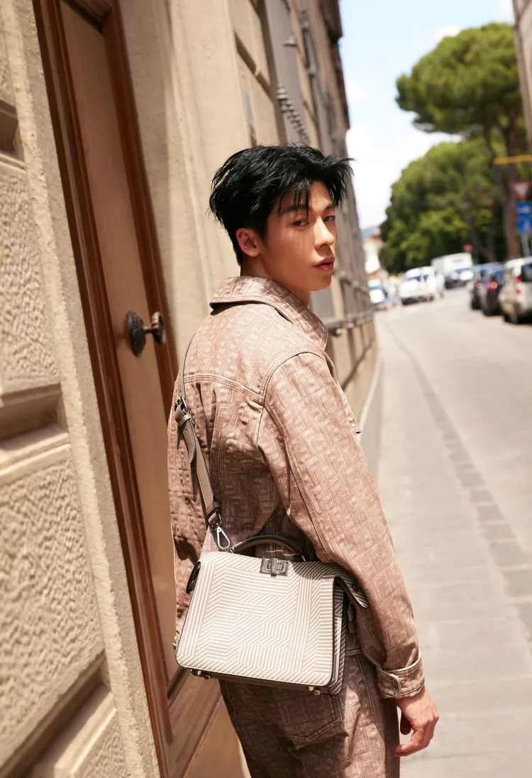 許光漢身著FENDI秋冬新款中的棕色Logo牛仔外套套裝，搭配男仕Peekaboo包款。品牌提供