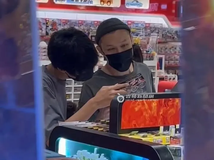 熱狗（右）和兒子一同看著戰鬥陀螺玩具。特勤中心攝