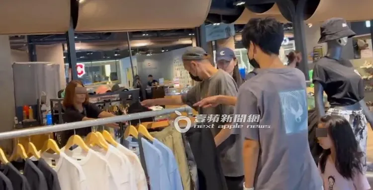 熱狗（左）挑好衣服拿給店員結帳。特勤中心攝
