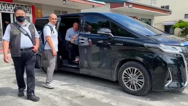 郭信良搭上座車，被載往地檢。讀者提供