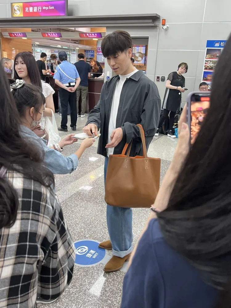 TETSUYA走出機場後落單，還留在大廳幫粉絲簽名。陳薇安攝