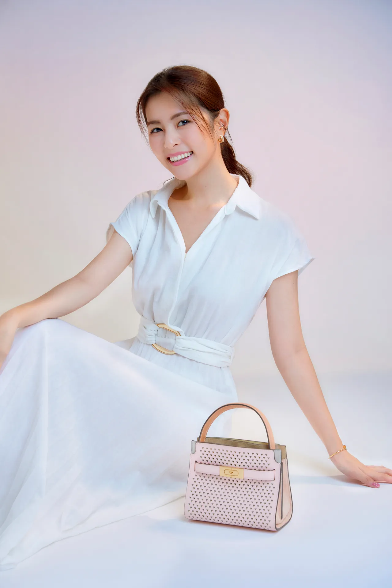 有愛情滋潤的任容萱，以TORY BURCH推出的新款Lee Radziwill迷你雙層肩背包，搭出有著粉紅泡泡的含蓄愛意。品牌提供