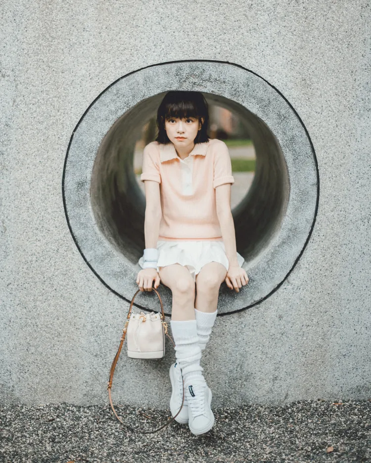 女星姚愛寗一襲粉色針織衫搭配同色系的TORY BURCH T Monogram迷你水桶包，給人滿滿戀愛感。品牌提供