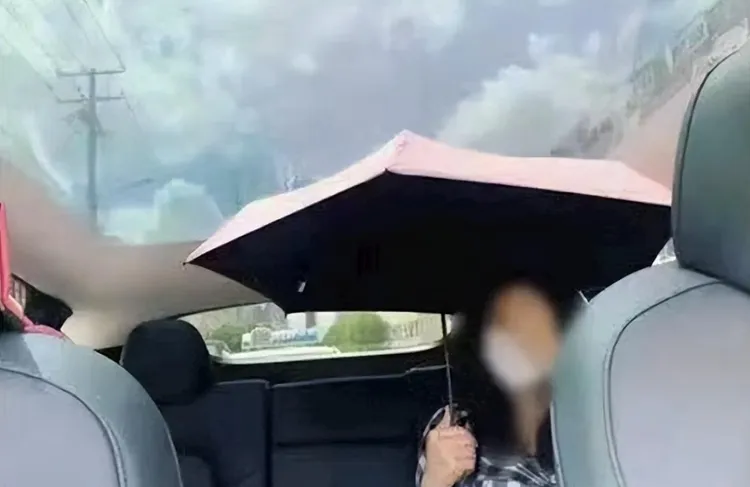 在電動車裡打傘。翻攝快科技