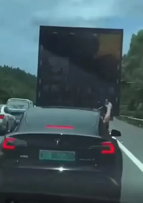 去年夏天有一段特斯拉副駕駛手動潑水給車降溫的影片在網絡上流傳，影片中一輛Model 3難忍曝曬，從副駕駛座伸出手不斷把礦泉水潑灑到車頂降溫。翻攝新浪微博