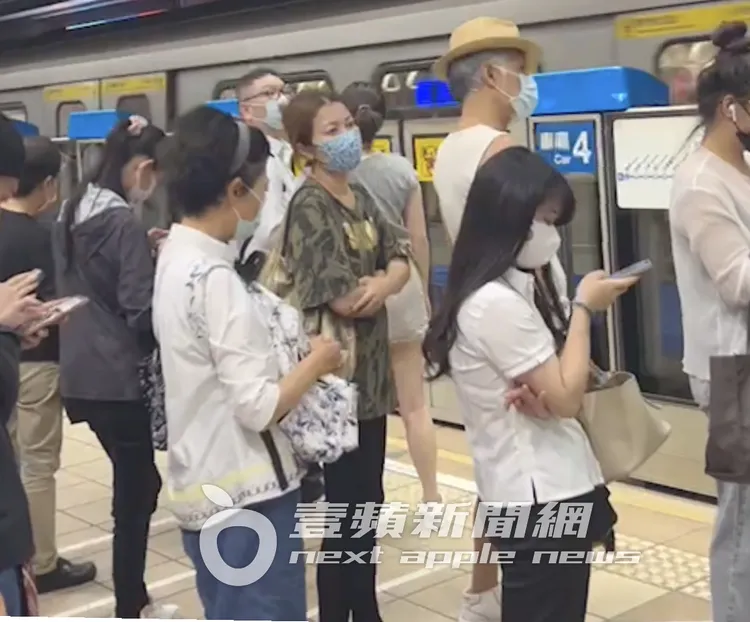 周禹侯（右）與輕熟女走進捷運忠孝復興站排隊等車。特勤中心攝