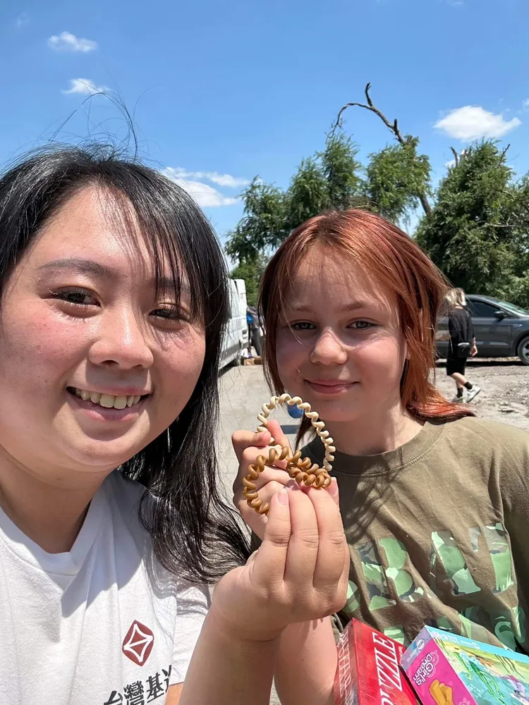 楊佩樺與孩童互動，和烏克蘭小妹妹交換髮圈。台灣基進提供