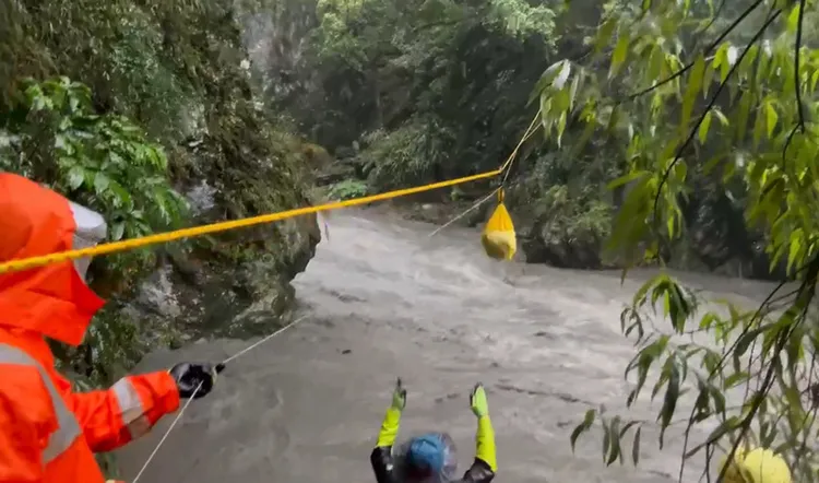 颱風杜蘇芮影響，台東縣海端鄉栗松溫泉26日上午溪水暴漲，前往露營的26歲台灣籍女子和29歲英國籍男子受困山坡，礙於水勢湍急，消防人員僅能先利用拋繩槍運送糧食和保暖衣物，所幸受困2人暫無危險。（台東縣消防局提供）中央社