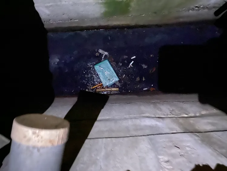 警方在附近水溝內發現被拔走的夾鏈袋及簽到表。民眾提供