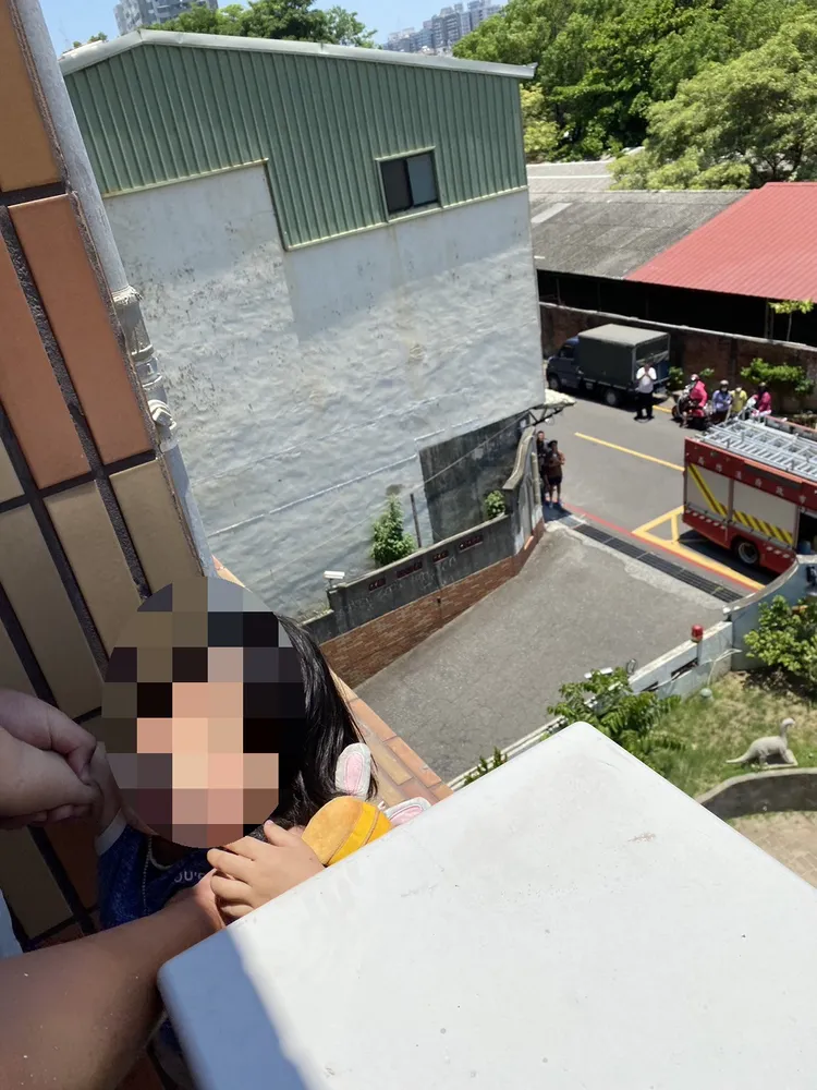 警消破門進屋，趕緊將小女孩抱回屋內。讀者提供