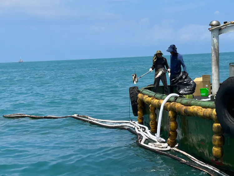 應變船隻以吸油棉索清除海面油污。海保署提供