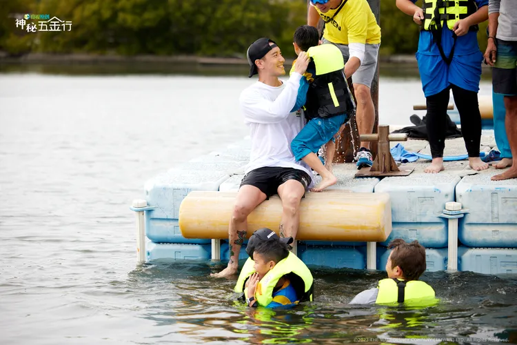 王陽明（中）跟小朋友一起玩水上活動，幫忙扶小朋友上岸。衛視提供