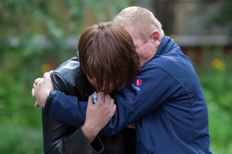 雙胞胎父母抱頭痛哭。路透社