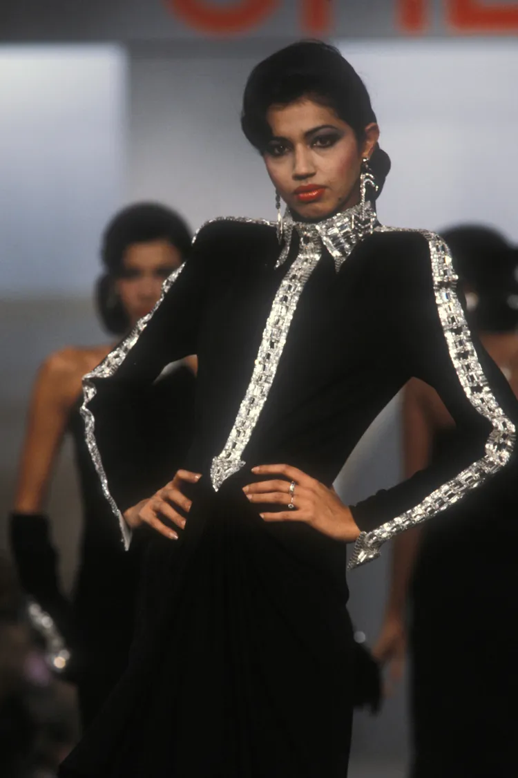 1983年秋冬系列的「Bugatti」立領洋裝，以水鑽縫飾出的巨大箭頭符號，還原了高速公路上的方向指示牌。品牌提供