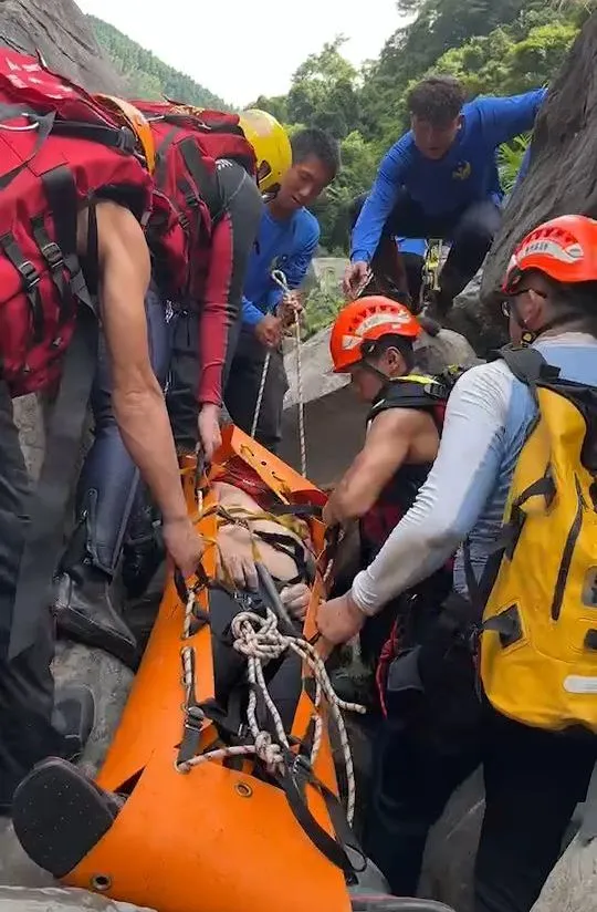 警消尋獲失蹤者遺體，合力搬運下山。新竹縣消防局提供
