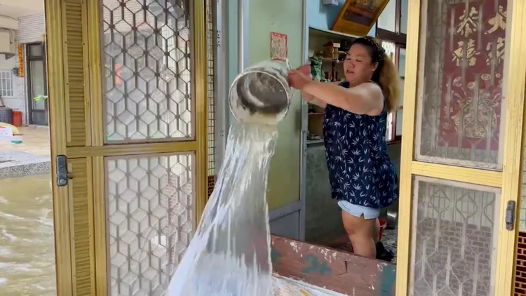 民眾在家舀水，再一桶桶往外倒。王志弘攝