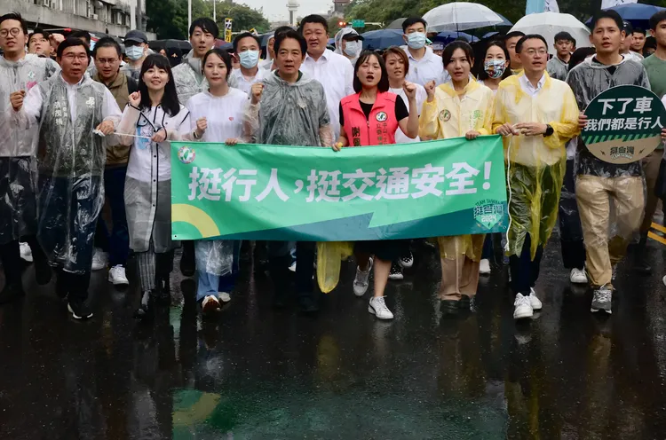 民進黨總統參選人賴清德率領黨公職冒雨走遊行，不過因中途停下拍照遭民眾酸作秀。林林攝