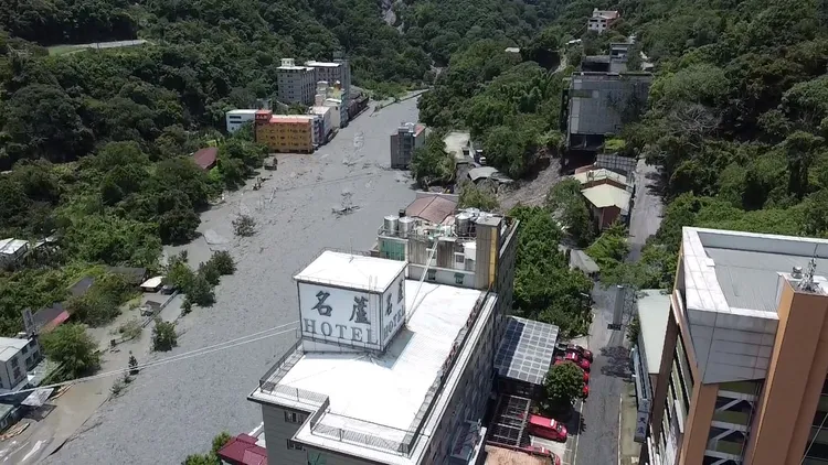 南投蘆山溫泉區空拍畫面，不少建築物地基被掏空，慘被土石流淹沒。消防署提供