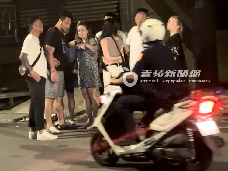 陳致遠（左二）與秀琴看到警察騎巡邏車過來，交頭接耳討論一番。特勤中心攝