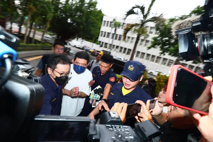 NONO一路低頭不語，被大批媒體包圍拍攝。彭欣偉攝