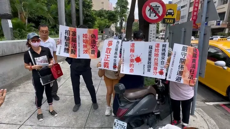賴姓高中生的親友、民眾在法庭外，針對賴男同婚配偶舉牌抗議。鮮明攝