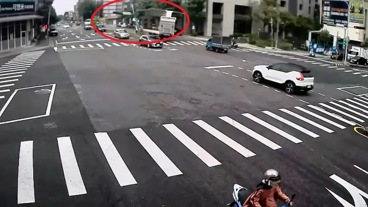 大貨車鷗翼車門撞倒號誌桿，剛好砸中一輛待轉的自小客車。民眾提供